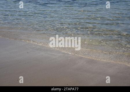 Costa mediterranea in inverno. Le onde del mare calme sulla spiaggia sabbiosa. Foto Stock