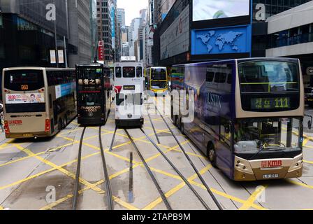 HONG KONG - 29 GIUGNO 2014: Tram e autobus a due piani su una strada di Hong Kong. Foto Stock