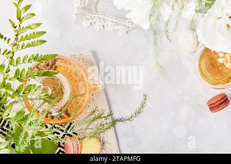 Tempo femminile e meditativo per te stesso. Tazza di tè alle erbe, dessert a base di macaroon, stile di vita piatto. Copia spazio. Foto Stock