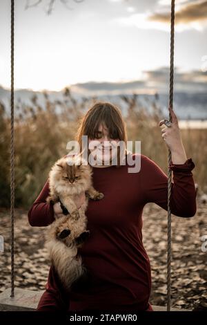 Splendida ambientazione all'esterno Ritratto Pretty Female Brown Hair con adorabile gatto scozzese Foto Stock