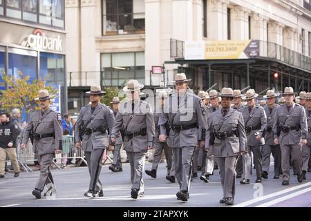 Decine di migliaia marciarono nella New York City Veterans Day Parade lungo la 5th Avenue a Manhattan. Gli agenti di polizia dello Stato di New York marciano nella parata. Foto Stock