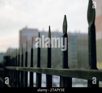 Vecchio recinto appuntito in ferro battuto nero da vicino in una prospettiva decrescente Foto Stock