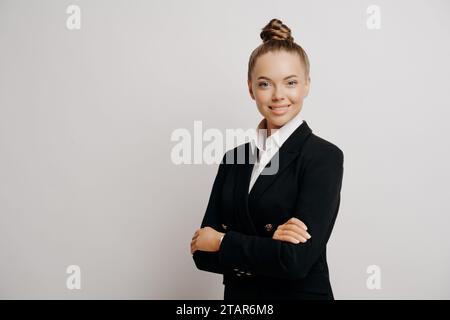 Segretaria professionale con un atteggiamento amichevole, vestita con un vestito nero, che trasuda competenza Foto Stock