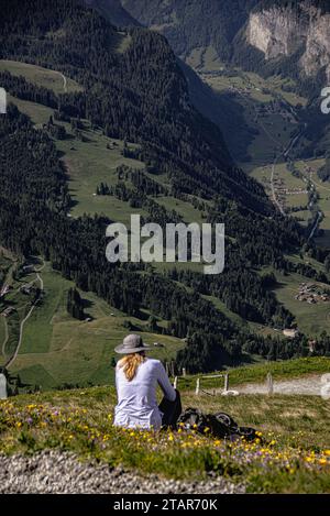 Una donna con un cappello che ammira la bellezza della montagna. Rilassatevi in cima alla montagna in Svizzera. Foto Stock