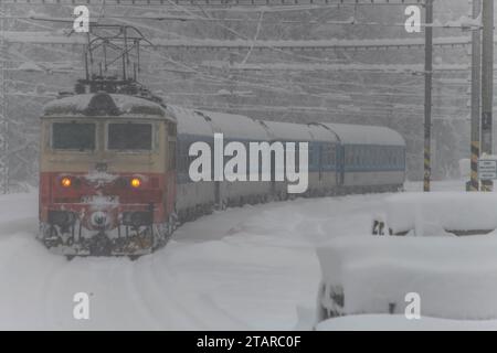 Treni elettrici vicino alla foresta innevata a Chotycany, CZ 12 02 2023 Foto Stock