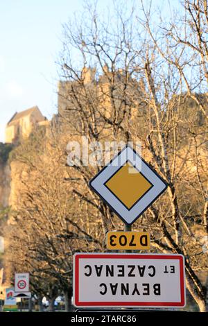 Beynac-et-Cazenac, Francia. 2 dicembre 2023. L'operazione dell'unione nazionale condotta dai sindacati agricoli ha chiamato "camminiamo sulla testa" per manifestare contro la politica agricola del governo. Questi agricoltori attivisti capovolgono i segnali che indicano i nomi delle aree urbane per denunciare oneri eccessivamente pesanti, importazioni di prodotti che indeboliscono notevolmente i redditi e concorrenza definita sleale rispetto a norme europee sempre più restrittive. In questa foto è il segno del villaggio rurale e turistico di Beynac-et-Cazenac in Dordogna, nel sud-ovest della Francia, che ha appena b Foto Stock