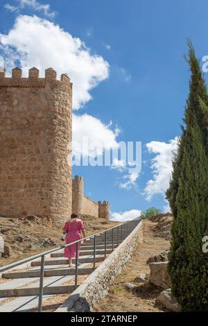 Donna che cammina per i bastioni nella città medievale fortificata spagnola di Aliva capitale della provincia spagnola di Avila in Castiglia e León in Spagna Foto Stock