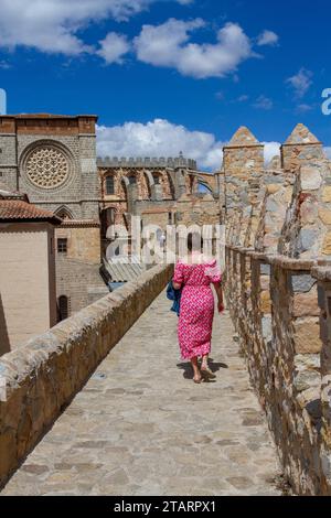 Donna che cammina sui bastioni delle mura della città fortificata nella città fortificata spagnola di Avila, nella comunità autonoma di Castiglia e León Spagna Foto Stock