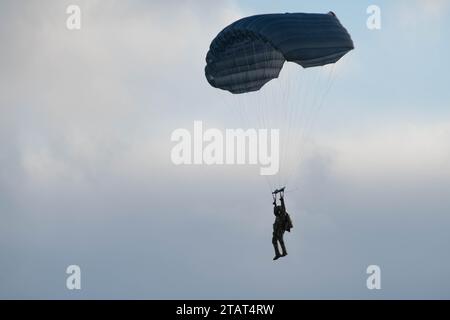 Un paracadutista dell'esercito degli Stati Uniti della 4th Quartermaster Company, 725th Brigade Support Battalion (Airborne), 2nd Infantry Brigade Combat Team (Airborne), 11th Airborne Division, discende sopra Malemute Drop zone durante l'addestramento militare in caduta libera presso Joint base Elmendorf-Richardson, Alaska, 30 novembre 2023. Air Force Special Warfare Airmen, Alaska Air National Guard aviatori e paracadutisti dell'esercito hanno condotto l'addestramento congiunto di supporto aereo per garantire la prontezza della missione in un ambiente artico. (Foto dell'aeronautica militare statunitense di Raina Dale) Foto Stock