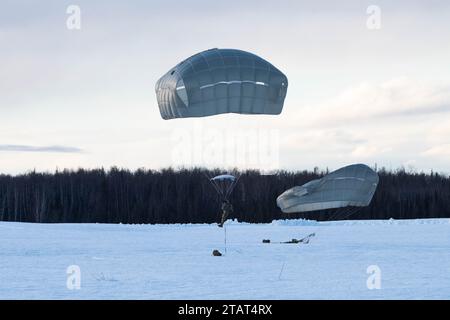 Paracadutisti dell'esercito degli Stati Uniti della 4th Quartermaster Company, 725th Brigade Support Battalion (Airborne), 2nd Infantry Brigade Combat Team (Airborne), 11th Airborne Division, conducono addestramento aereo a Malemute Drop zone, Joint base Elmendorf-Richardson, Alaska, 30 novembre 2023. Air Force Special Warfare Airmen, Alaska Air National Guard aviatori e paracadutisti dell'esercito hanno condotto l'addestramento congiunto di supporto aereo per garantire la prontezza della missione in un ambiente artico. (Foto dell'aeronautica militare statunitense di Raina Dale) Foto Stock