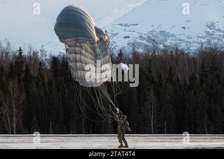 Un paracadutista dell'esercito statunitense della 4th Quartermaster Company, 725th Brigade Support Battalion (Airborne), 2nd Infantry Brigade Combat Team (Airborne), 11th Airborne Division, atterra sulla Malemute Drop zone durante l'addestramento militare in caduta libera presso Joint base Elmendorf-Richardson, Alaska, 30 novembre 2023. Air Force Special Warfare Airmen, Alaska Air National Guard aviatori e paracadutisti dell'esercito hanno condotto l'addestramento congiunto di supporto aereo per garantire la prontezza della missione in un ambiente artico. (Foto dell'aeronautica militare statunitense di Raina Dale) Foto Stock