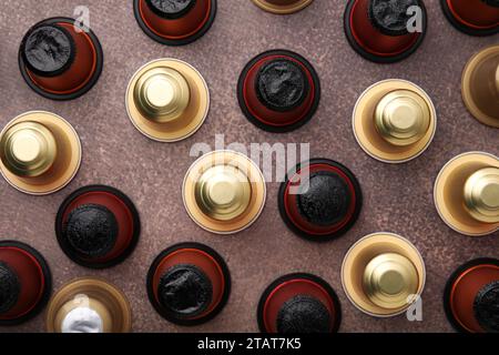 Molte capsule di caffè su un tavolo marrone, posato in piano Foto Stock