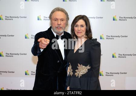 Billy Crystal punta verso i fotografi mentre lui e sua moglie, Janice Crystal arrivano per la cerimonia di Medallion in onore dei destinatari del 46th Annual Kennedy Center Honors presso il Dipartimento di Stato di Washington, DC sabato 2 dicembre 2023. Gli onorati del 2023 sono: L'attore e comico Billy Crystal; l'acclamato soprano Renee Fleming; il cantautore britannico produttore e membro dei Bee Gees, Barry Gibb; il rapper, cantante e attrice Queen Latifah; e il cantante Dionne Warwick.Credit: Ron Sachs/Pool via CNP Foto Stock