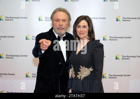 Billy Crystal punta verso i fotografi mentre lui e sua moglie, Janice Crystal arrivano per la cerimonia di Medallion in onore dei destinatari del 46th Annual Kennedy Center Honors presso il Dipartimento di Stato di Washington, DC sabato 2 dicembre 2023. I 2023 onorati sono: L'attore e comico Billy Crystal; l'acclamato soprano Renee Fleming; il cantautore britannico produttore e membro dei Bee Gees, Barry Gibb; il rapper, cantante e attrice Queen Latifah; e la cantante Dionne Warwick. Credito: Ron Sachs/Pool tramite CNP Foto Stock