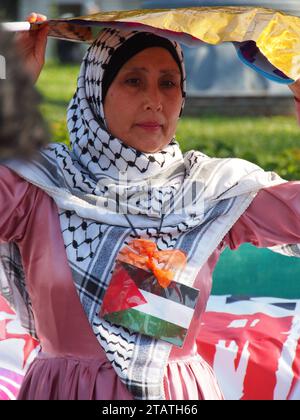 Lima, Perù. 2 dicembre 2023. Una mujer con una bandera palestina e el pecho cuando decine di persone si sfidano per le strade di Lima nell'ambito delle attività per la giornata internazionale della solidarietà con il popolo palestinese, che si celebra ogni novembre 29 credito: Agenzia stampa Fotoholica/Alamy Live News Foto Stock