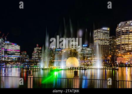 Enormi spruzzi d'acqua e luci colorate a Cockle Bay, Darling Harbour, Sydney, Australia, durante il Vivid Festival nel giugno 2023 Foto Stock