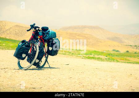 Pedalò per escursioni in bicicletta su una strada panoramica di ghiaia immersa nella natura. Macchina da turismo completamente carica con sfondo spazio di copia Foto Stock