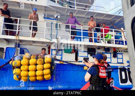 Oceano Pacifico. 23 ottobre 2023. Gli uomini della Guardia Costiera a bordo del cutter della Guardia Costiera Frederick Hatch usano le traduzioni su una tavoletta per fare domande sull'imbarco ai membri dell'equipaggio filippino su una nave nell'Oceano Pacifico, 23 ottobre 2023. (Immagine di credito: © U.S. Coast Guard/ZUMA Press Wire) SOLO PER USO EDITORIALE! Non per USO commerciale! Foto Stock