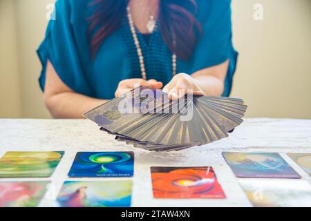 Una donna che pratica la predica con le carte dei tarocchi Foto Stock