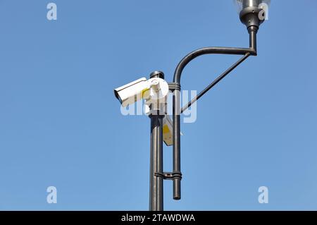 Sicurezza della telecamera CCTV su palo. Moderna telecamera di sorveglianza a circuito chiuso sul lampione di una strada cittadina Foto Stock