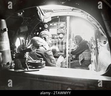 LANCASTER BOMBER interno circa 1943 con operatore radio a sinistra e navigatore. Davanti all'operatore radio si trova il trasmettitore Marconi T1154 sopra un ricevitore Marconi R1154. Foto Stock