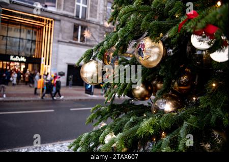 Berlino, Germania. 3 dicembre 2023. La gente passa dietro un albero di Natale al grande magazzino Kaufhaus des Westens (KaDeWe) di domenica, quando è aperto per lavoro. Credito: Fabian Sommer/dpa/Alamy Live News Foto Stock