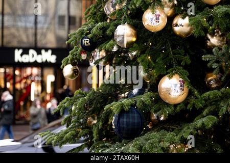 Berlino, Germania. 3 dicembre 2023. La gente passa dietro un albero di Natale al grande magazzino Kaufhaus des Westens (KaDeWe) di domenica, quando è aperto per lavoro. Credito: Fabian Sommer/dpa/Alamy Live News Foto Stock