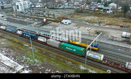 OLDENZAAL, PAESI BASSI - 2 DICEMBRE 2023: Vista aerea di una locomotiva delle Ferrovie olandesi (NS) di fronte ad alcuni vagoni passeggeri delle Ferrovie tedesche (DB). Foto Stock