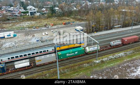 OLDENZAAL, PAESI BASSI - 2 DICEMBRE 2023: Vista aerea di una locomotiva delle Ferrovie olandesi (NS) di fronte ad alcuni vagoni passeggeri delle Ferrovie tedesche (DB). Foto Stock