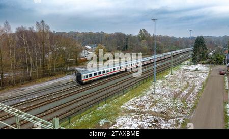 OLDENZAAL, PAESI BASSI - 2 DICEMBRE 2023: Vista aerea di una locomotiva delle Ferrovie olandesi (NS) di fronte ad alcuni vagoni passeggeri delle Ferrovie tedesche (DB). Foto Stock