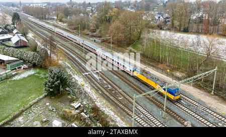 OLDENZAAL, PAESI BASSI - 2 DICEMBRE 2023: Vista aerea di una locomotiva delle Ferrovie olandesi (NS) di fronte ad alcuni vagoni passeggeri delle Ferrovie tedesche (DB). Foto Stock