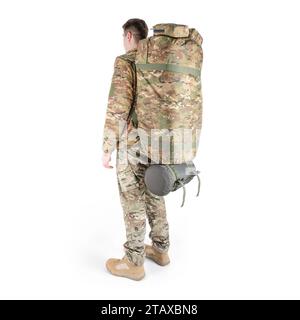 Soldato in uniforme militare con uno zaino mimetico sulle spalle su sfondo bianco. Vista posteriore. Foto Stock