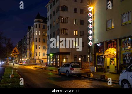 Vista della via Aleksis Kiven katu dopo il tramonto con cartello Populus dive bar nel quartiere Harju di Helsinki, Finlandia Foto Stock