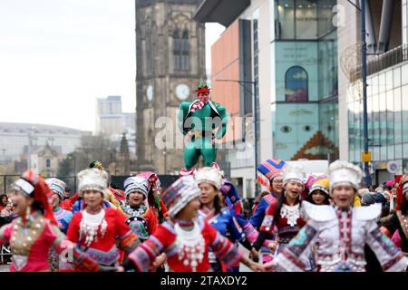 Manchester, Regno Unito. 3 dicembre 2023. La parata natalizia di Manchester è in corso per le strade della città, con tutti i personaggi abituali come Babbo Natale e gli elfi della vita reale. Una Pipe band e un gruppo di batteristi Salva forniscono alcuni dei suoni con le famiglie che fiancheggiano le strade per dare un'occhiata ad alcuni dei burattini giganti e al globo a grandezza naturale con Snow Queen. Manchester, Regno Unito. Foto Stock