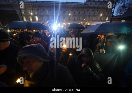 La gente tiene le candele durante una veglia anti-odio a Whitehall, nel centro di Londra. L'evento chiamato Building Bridges, Together for Humanity, parla sia contro l'antisemitismo che contro l'odio anti-musulmano e ci invita a proteggere le relazioni della comunità nel Regno Unito. Data immagine: Domenica 3 dicembre 2023. Foto Stock