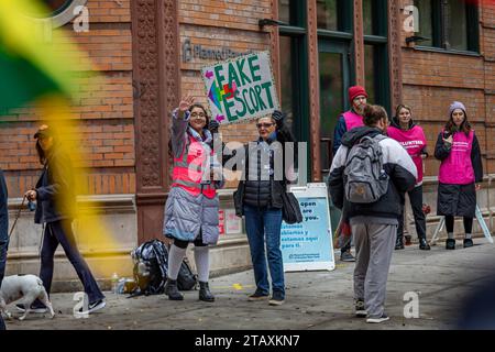 NEW York, NEW YORK - 2 DICEMBRE: Un attivista per i diritti dell'aborto tiene un cartello "Fake Escort" accanto a un avvocato anti-aborto mascherato come un lavoratore di Planned Parenthood nel tentativo di dissuadere i pazienti dal ricevere cure il 2 dicembre 2023 a New York City. (Foto di Michael Nigro/Sipa USA) credito: SIPA USA/Alamy Live News Foto Stock