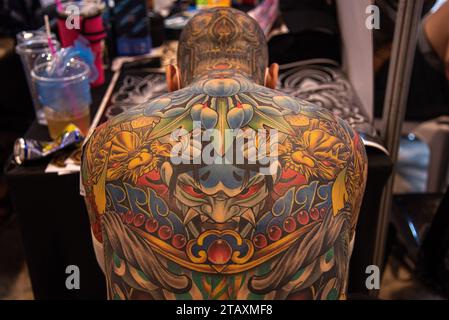 Bangkok, Thailandia. 3 dicembre 2023. Un concorrente si prepara a presentare il suo tatuaggio durante la Land of Ink Bangkok Tattoo Convention 2023 al ChangChui Creative Park di Bangkok. Centinaia di artisti e appassionati di tatuaggi professionisti nazionali e internazionali partecipano alla Land of Ink Bangkok Tattoo Convention 2023 per mostrare le loro abilità di design in un concorso di tatuaggi. Credito: SOPA Images Limited/Alamy Live News Foto Stock