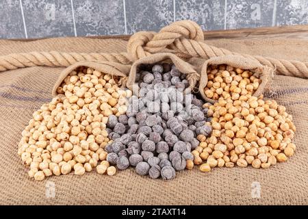 Varietà di nocciole su fondo di lino e torni di lino. Nocciole tostate sgusciate, nocciole sgusciate e nocciole tostate senza guscio. Cibo sano co Foto Stock