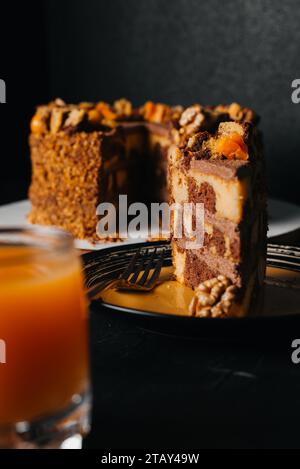 torta di carote con noci, prugne e albicocche secche su fondo di legno scuro. tintura. fuoco selettivo Foto Stock