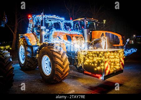 Lichterfahrt - mit bunt leuchtenden Lichterketten geschmückte Traktoren stehen auf einem Sammelplatz, Symbolfoto. In der Adventszeit haben sich in den vergangenen Jahren die sogenannten Lichterfahrten von Landwirten mit ihren Traktoren zu einem highlight bei der ländlichen Bevölkerung entwickelt. Dabei fahren die mit zahllosen Lichterketten und bunter Weihnachtsdekoration geschmückten Trakoren im Konvoi oftmals durch mehrere Ortschaften. Ingresso Dieses foto AM 01. Dezember 2023 auf dem Marktgelände in Diepholz, Die Kolonne von insgesamt 88 Schleppern startete dabei in Wagenfeld und fuhr weite Foto Stock