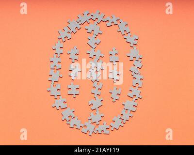 Cervello composto da pezzi di puzzle su sfondo arancione, spazio copia Foto Stock