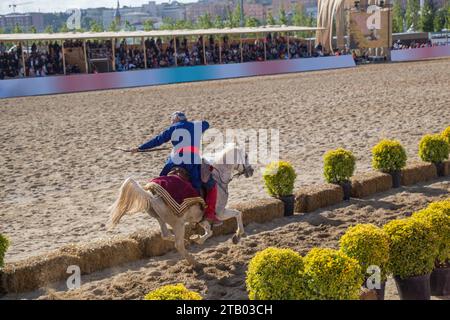 Equitazione con archer in abiti etnici a cavallo Foto Stock