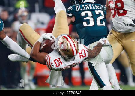 Philadelphia, Stati Uniti. 3 dicembre 2023. Il running back dei San Francisco 49ers Elijah Mitchell (25) fu sconfitto dalla safety Reed Blankenship dei Philadelphia Eagles (32) durante la seconda metà dell'azione della NFL al Lincoln Financial Field di Philadelphia domenica 3 dicembre 2023. Foto di Laurence Kesterson/UPI Credit: UPI/Alamy Live News Foto Stock