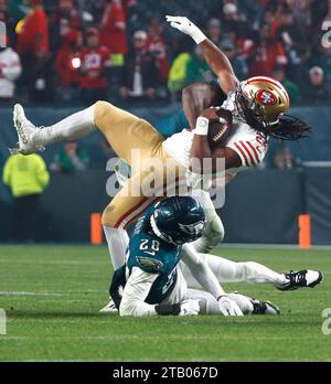 Philadelphia, Stati Uniti. 3 dicembre 2023. Il running back dei San Francisco 49ers Jordan Mason (24) viene fermato dal cornerback dei Philadelphia Eagles Josh Jobe (28) durante la seconda metà dell'azione della NFL al Lincoln Financial Field di Philadelphia domenica 3 dicembre 2023. Foto di Laurence Kesterson/UPI Credit: UPI/Alamy Live News Foto Stock