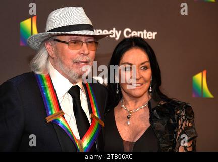 Washington, Stati Uniti. 3 dicembre 2023. 2023 Kennedy Center Honoree il musicista britannico Barry Gibb dei Bee Gees posa con sua moglie Linda Gray per i fotografi mentre arrivano per una serata di gala a Washington, DC domenica 3 dicembre 2023. Le onorificenze vengono premiate per un successo a vita nelle arti e nella cultura. Foto di Mike Theiler/UPI Credit: UPI/Alamy Live News Foto Stock