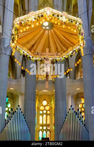 La Sagrada Família altare maggiore baldacchino con Gesù Cristo sulla croce da Antoni Galdí e canne d'organo, Barcellona, Spagna Foto Stock