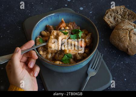 Stufato di trippa con pane su sfondo nero Foto Stock