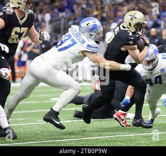 New Orleans, USA. 3 dicembre 2023. Il quarterback dei New Orleans Saints Taysom Hill (7) tentò di superare il defensive end dei Detroit Lions Aidan Hutchinson (97) durante una partita della National Football League al Caesars Superdome di New Orleans, Louisiana, domenica 3 dicembre 2023. (Foto di Peter G. Forest/Sipa USA) credito: SIPA USA/Alamy Live News Foto Stock