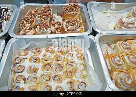 Primi piani di rotoli assortiti di cioccolato e cannella a nocciola in vassoi di alluminio Foto Stock