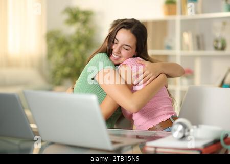 Due studenti felici che si abbracciano mentre studiano a casa Foto Stock